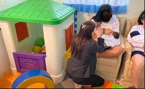 Enfermeira Graziela auxiliando uma mãe a amamentar